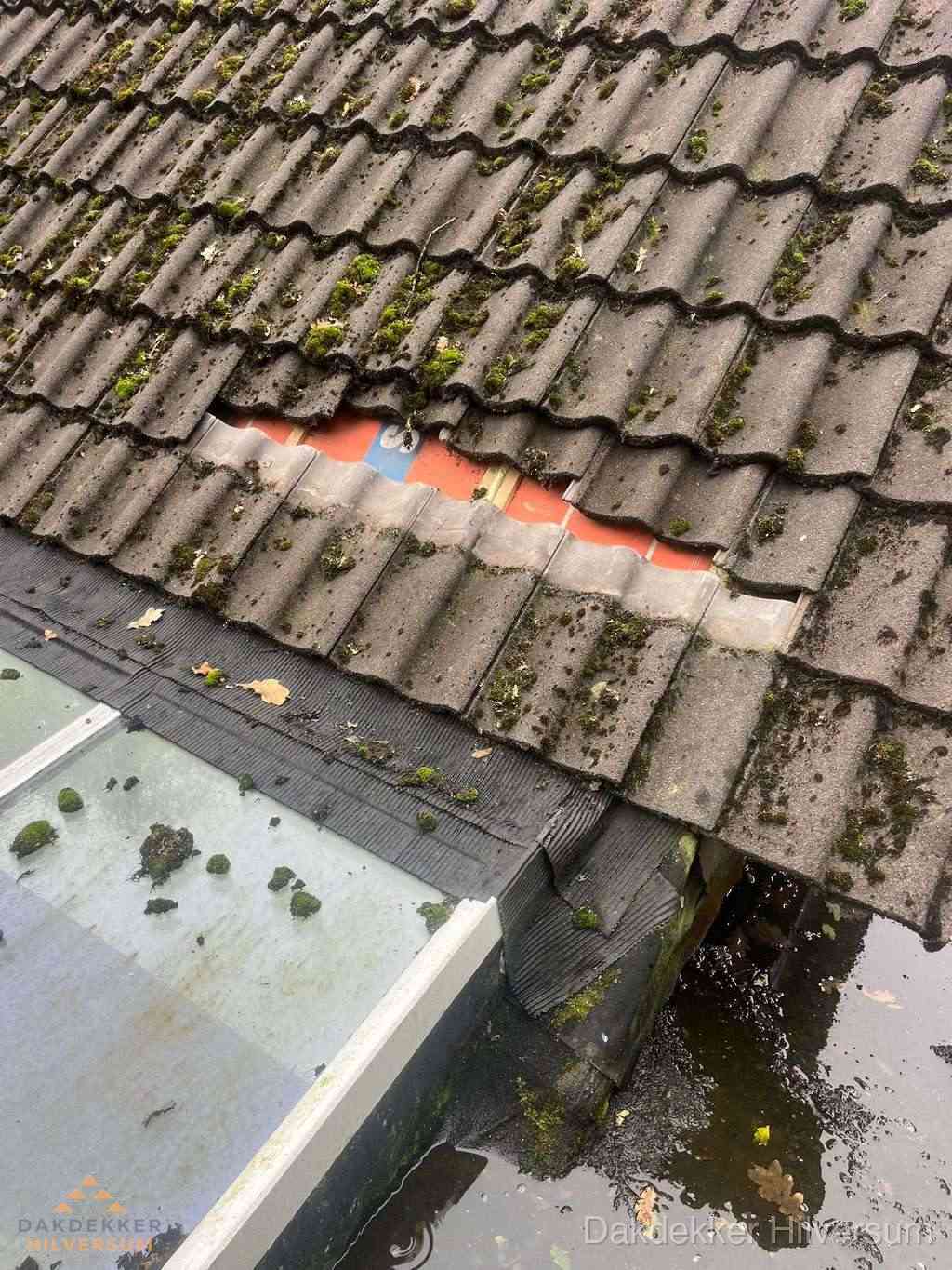 Beschadigd pannendak met ontbrekende dakpannen voor reparatie in Hilversum