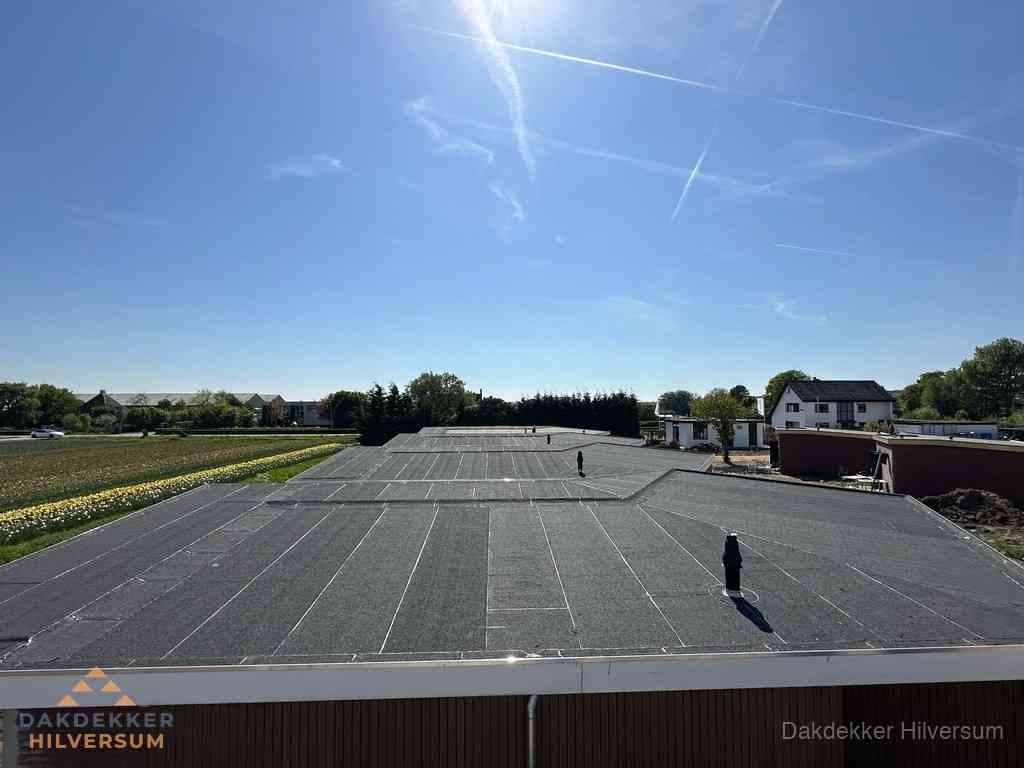 Groot plat dak met bitumen dakbedekking op bedrijfspand in Hilversum