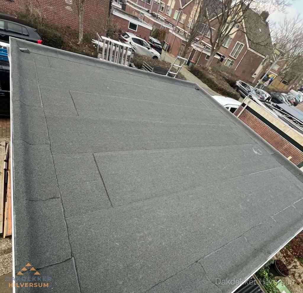 Nieuwe bitumen dakbedekking op plat dak van garage in Hilversum