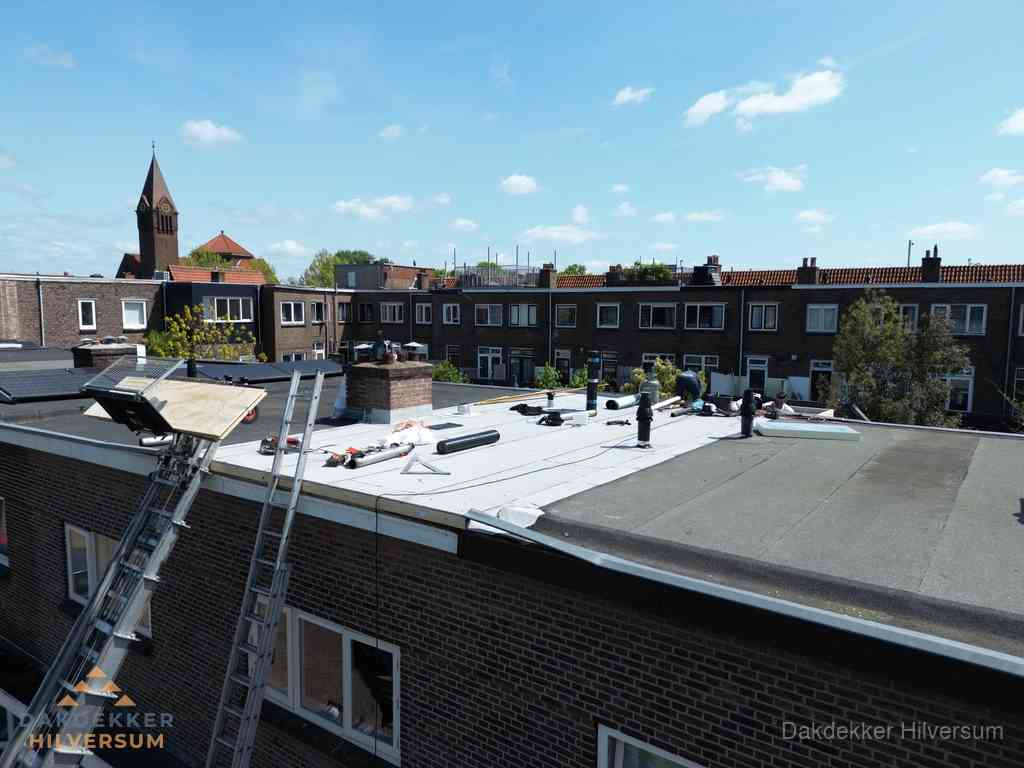 Dakdekkers aan het werk op plat dak in Hilversum