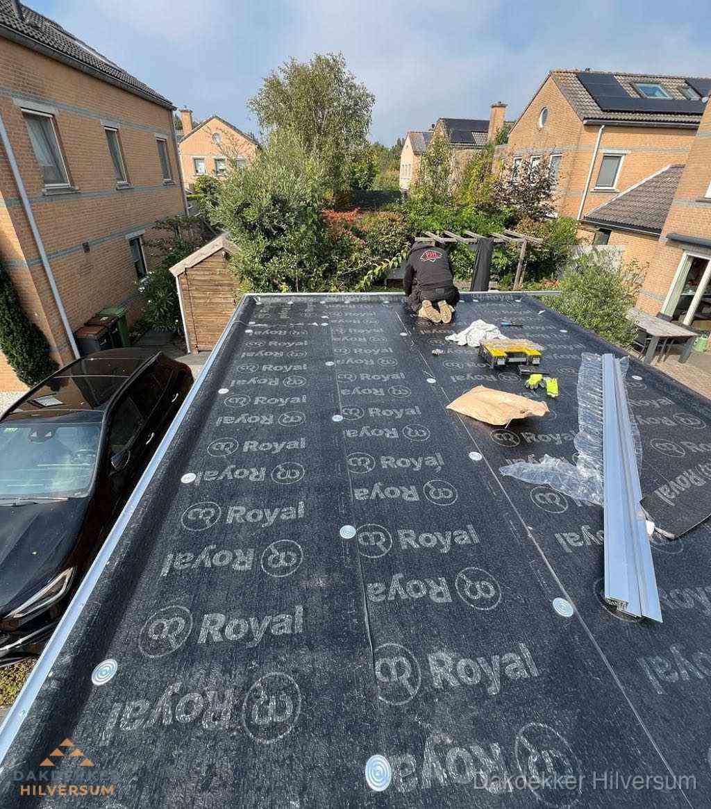 Dakdekker aan het werk op plat dak renovatie in Hilversum
