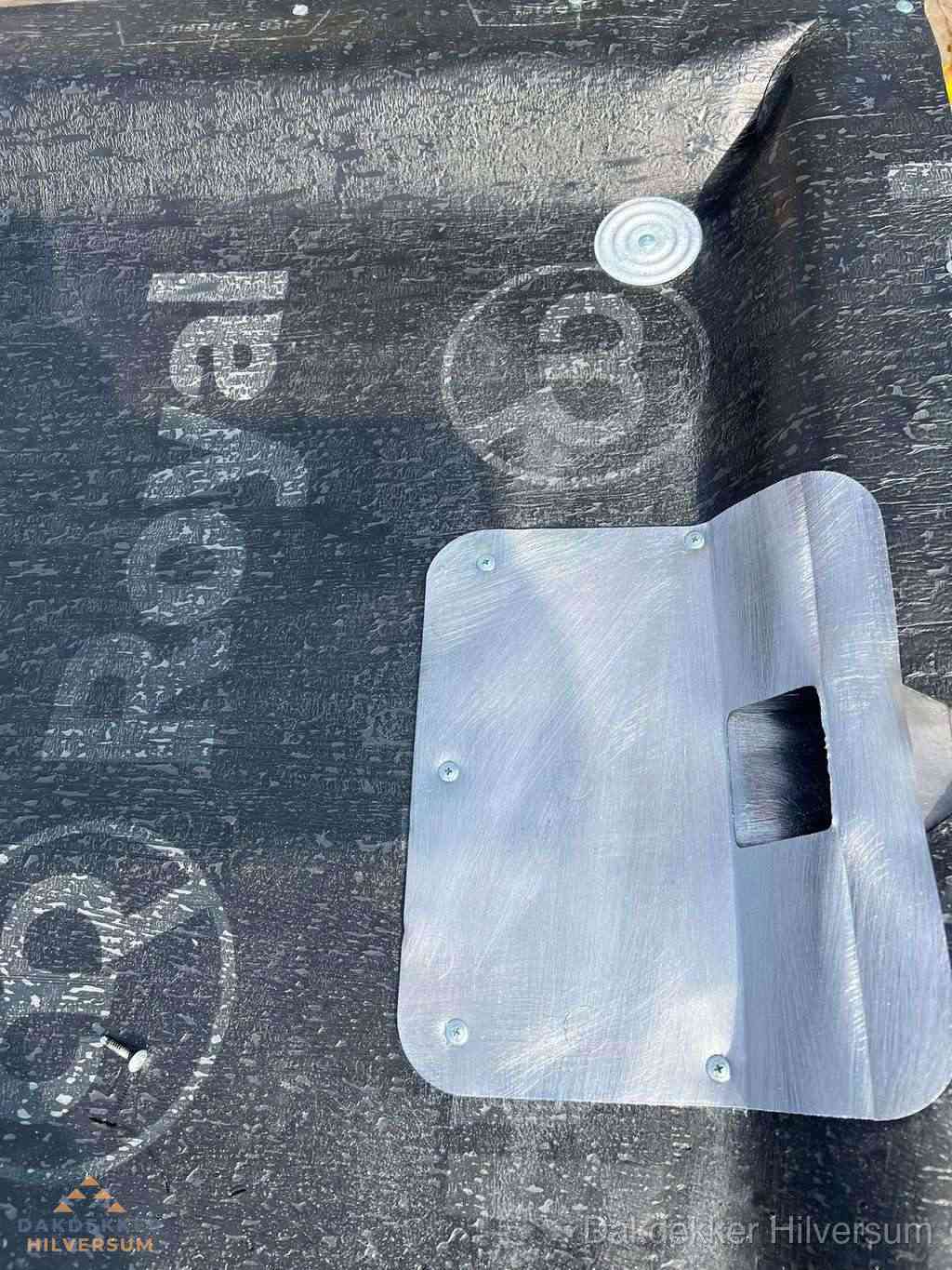 Dakdoorvoer met metalen afvoerplaat op bitumen dak in Hilversum