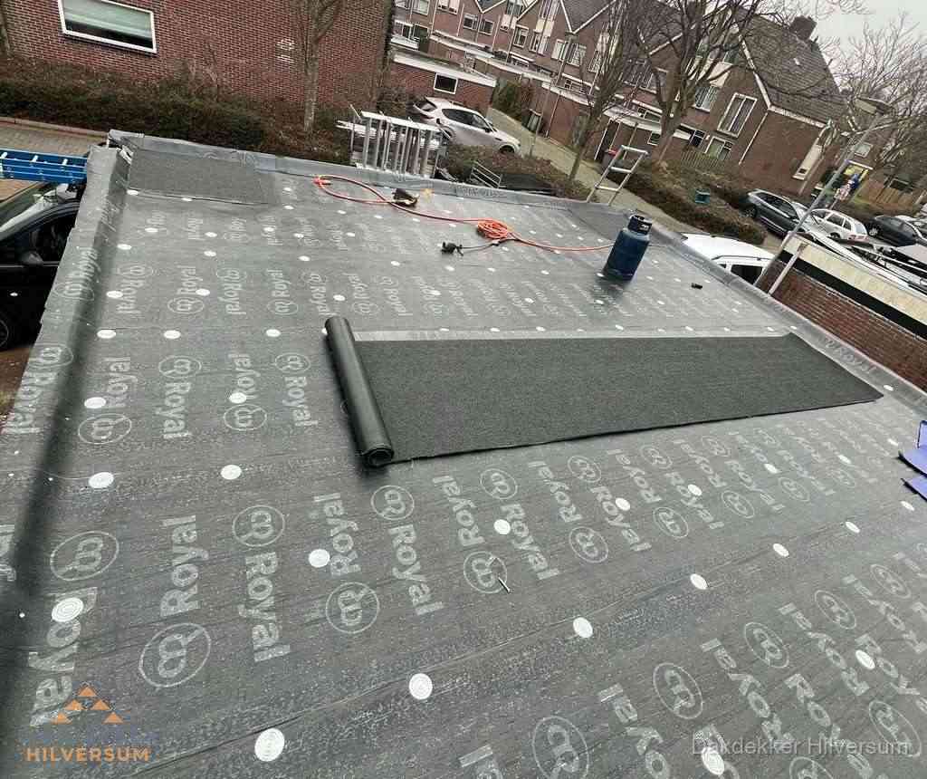 Dakdekker aan het werk met gasbrander op plat bitumen dak in Hilversum