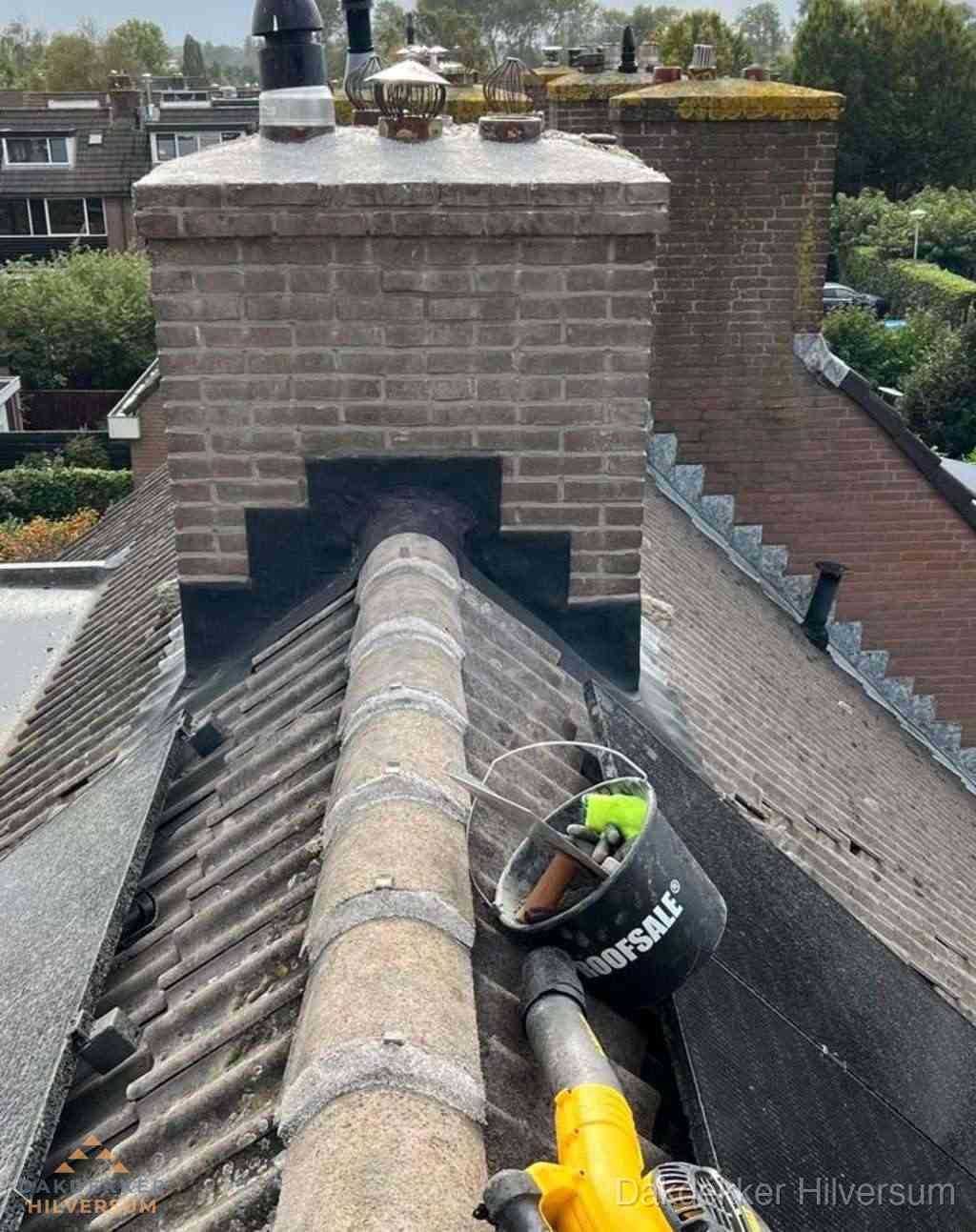 Dakdekker repareert bitumen dakleer bij dakdoorvoer in Hilversum