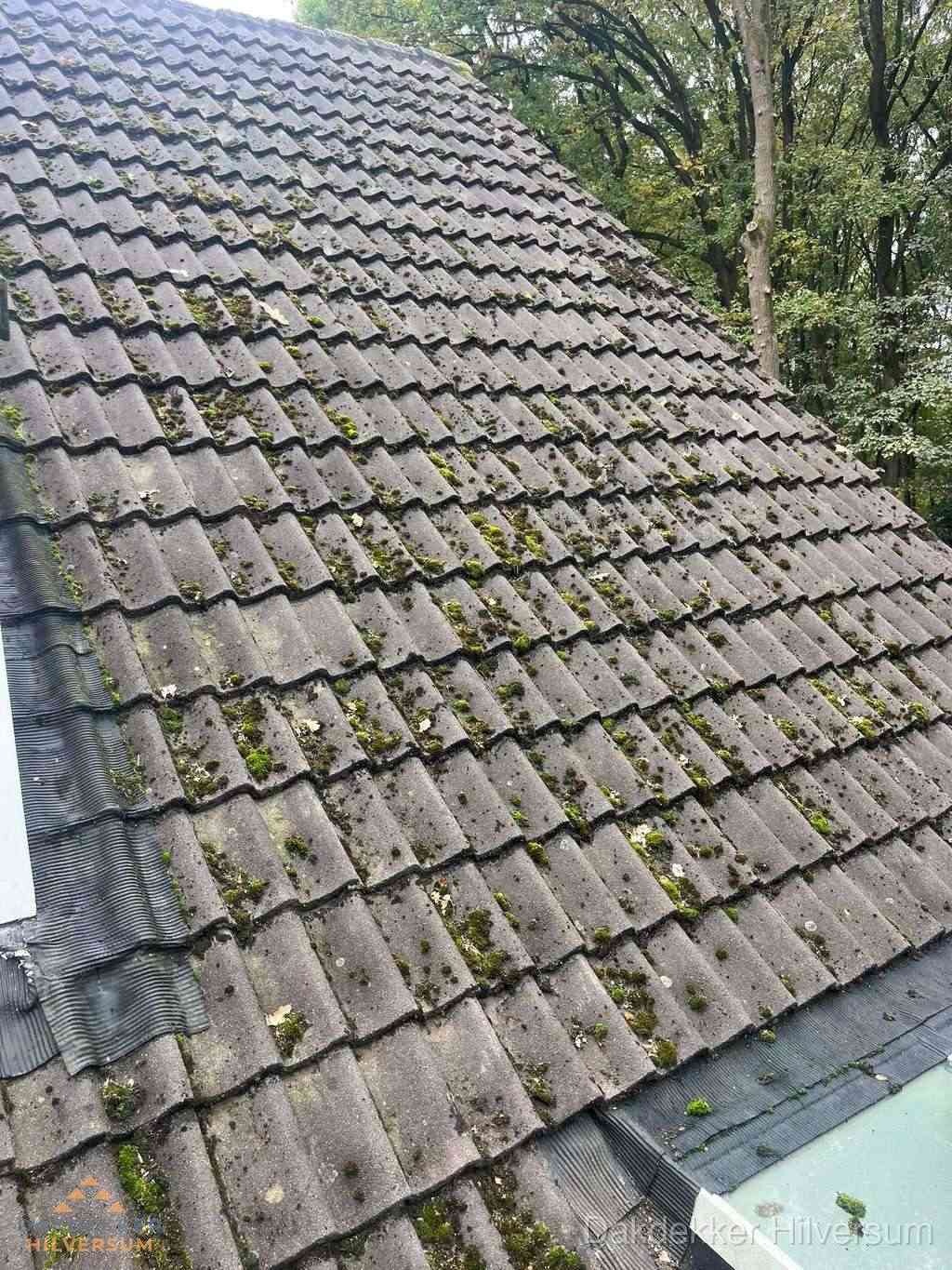 Verweerd pannendak met mosgroei dat renovatie nodig heeft in Hilversum